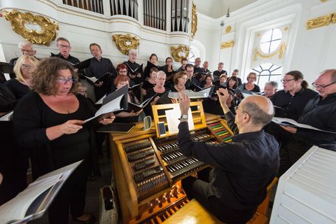 Der Chor singt, Christian von Blohn leitet vom Spieltisch der Orgel aus